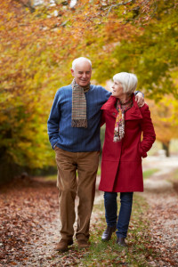 Senior Couple Walking Along Autumn Path